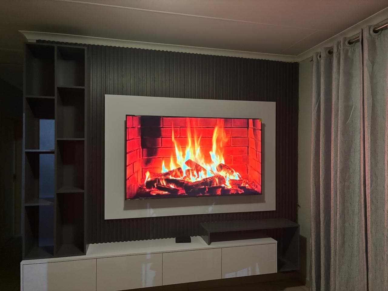 Modern charcoal slatted TV feature wall with white floating cabinetry