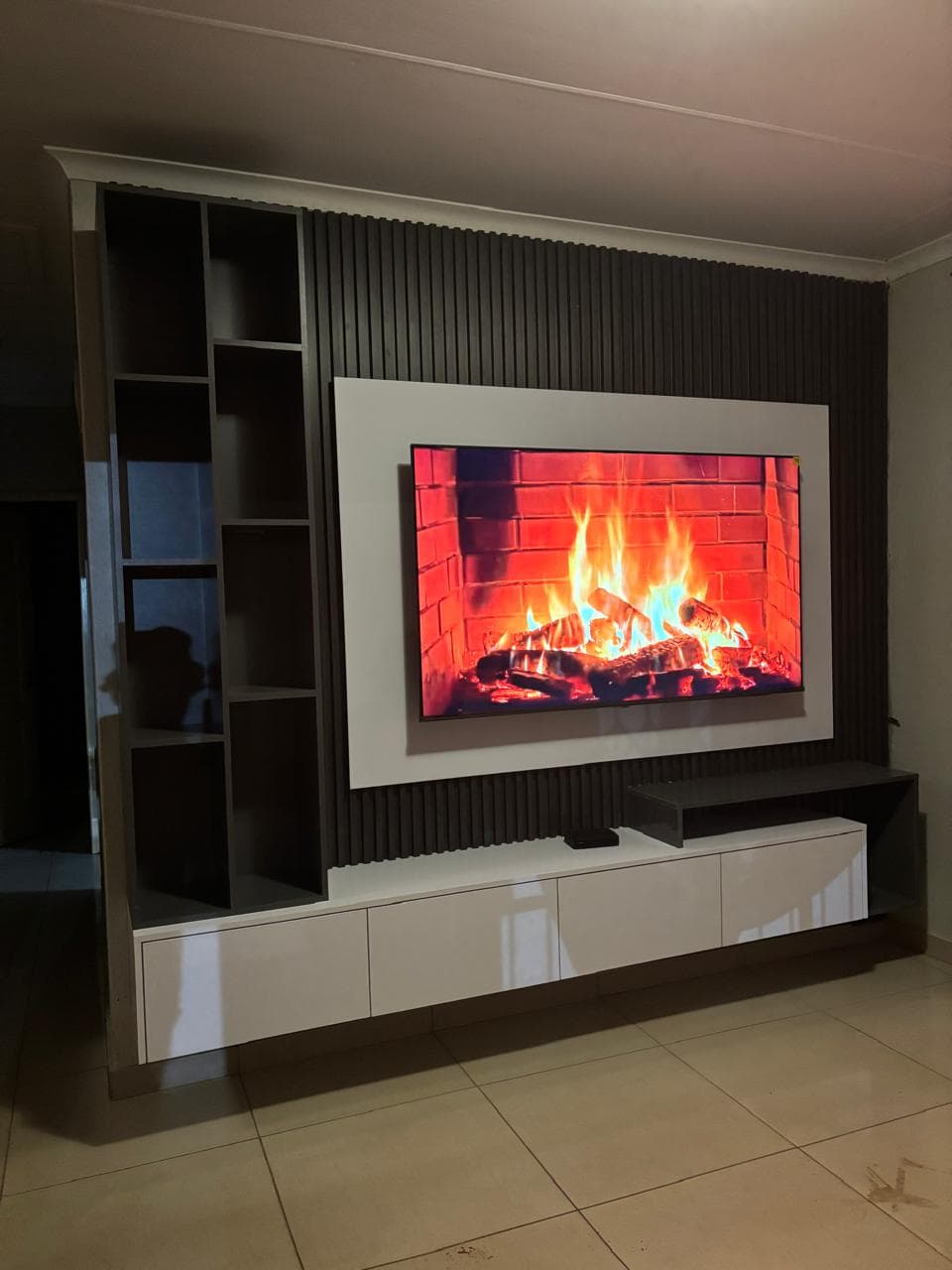 Charcoal slatted TV wall unit with a white console and open shelving