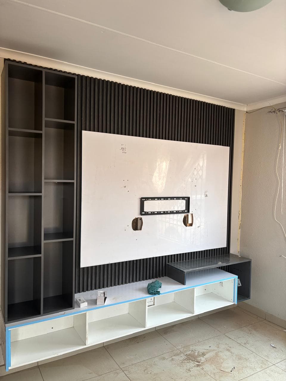 TV wall unit build with a slatted feature wall and floating base units
