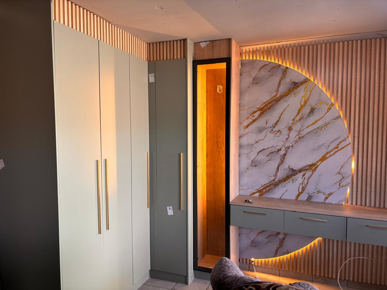 Built-in bedroom cupboards with a curved marble feature wall